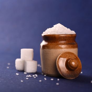 Sugar. white granulated sugar and refined sugar on a blue background