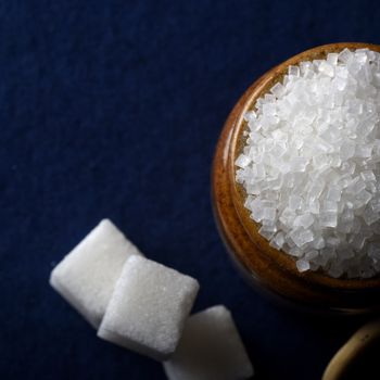 Sugar. white granulated sugar and refined sugar on a blue background