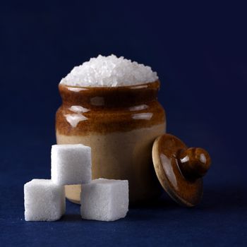 Sugar. white granulated sugar and refined sugar on a blue background