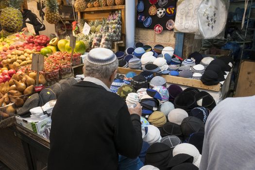 Jerusalem,Israel,29-march-2019:man shopping for new Traditional Kippah Yarmulke Jewish Hats on Display in the souk in Jerusalem, the souk is the most famous market in Jerusalem