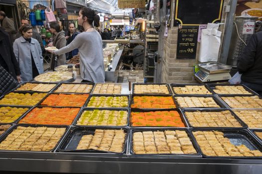 Jerusalem,Israel,29-march-2019:woman offerts tourist to tatste the sweet candy in the souk in Jerusalem, the souk is the most famous market in Jerusalem