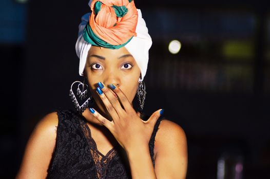 Young woman expressing surprise by putting her hand on his mouth.