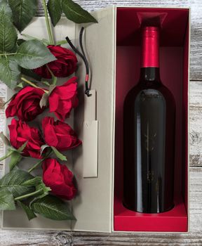 Happy Valentines Day with red roses and wine in a gift box 