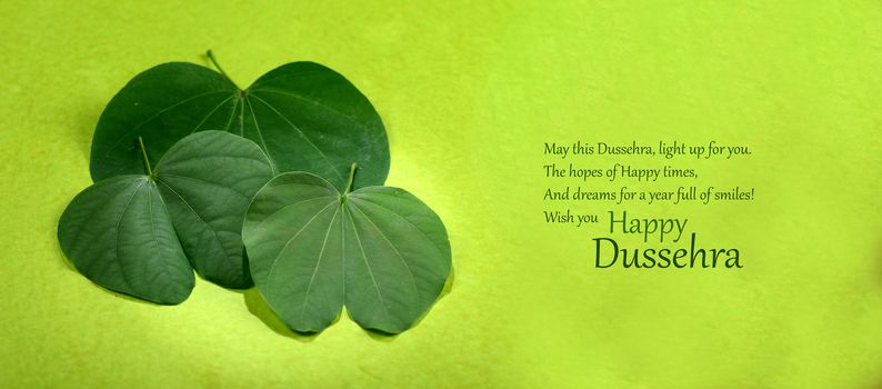 Indian Festival Dussehra, showing golden leaf and flowers on green background. Greeting card.