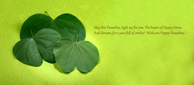 Indian Festival Dussehra, showing golden leaf and flowers on green background. Greeting card.