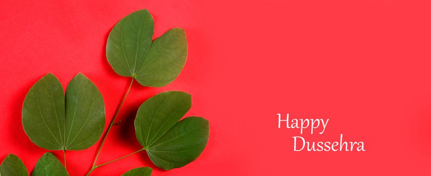 Indian Festival Dussehra, showing golden leaf on red background. Greeting card.