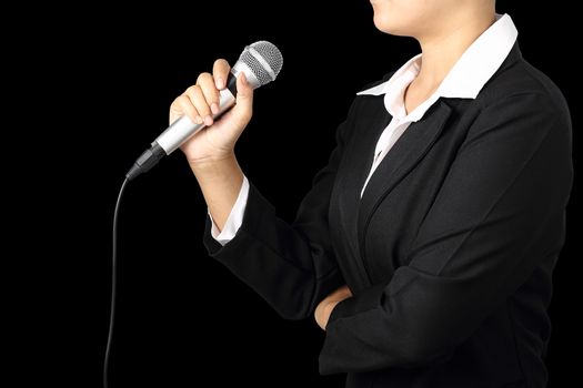 Woman hand holding a microphone isolated on black background, clipping path