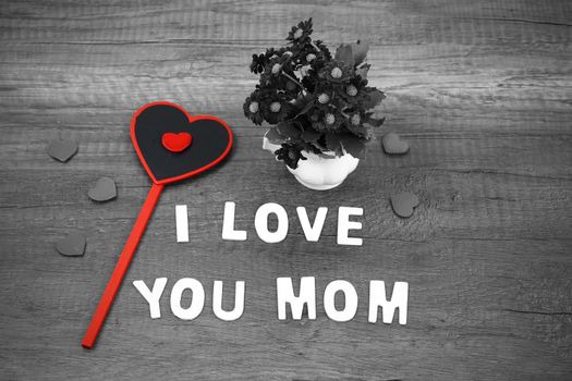 I love you mom wording with pink flower on old wooden background, Mother's day concept.