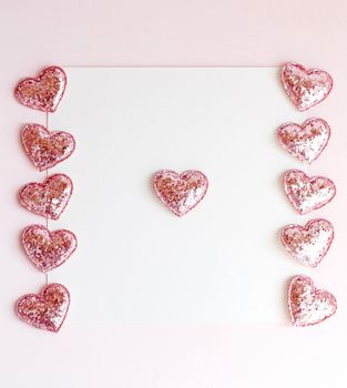 Background with copy space blank on pink background with pink glittered hearts, eucalyptus branch. White paper top view, flat lay, minimal style. Moke up card