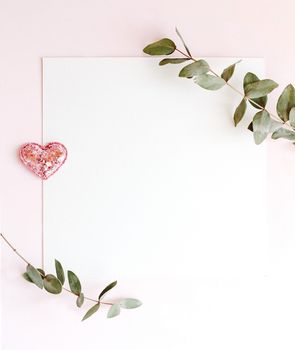 Background with copy space blank on pink background with pink glittered hearts, eucalyptus branch. White paper top view, flat lay, minimal style. Moke up card