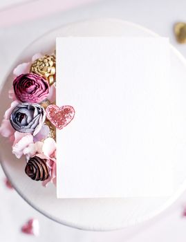 Background with copy space blank on table with glitter heart, eucalyptus branch, flowers and leafs. White paper top view, flat lay, minimal style. Moke up card