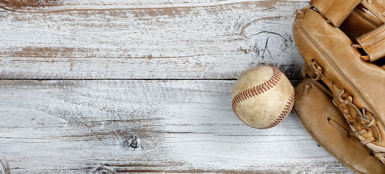 Overhead view of baseball and mitt on white vintage wood 