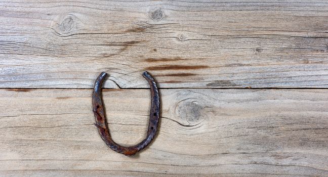 rusty horseshoe on rustic wooden boards in overhead view 