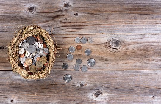 Flat view of nest egg filled with coin money on rustic wooden background with copy space