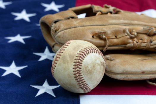 Baseball and mitt with United States flag in background 