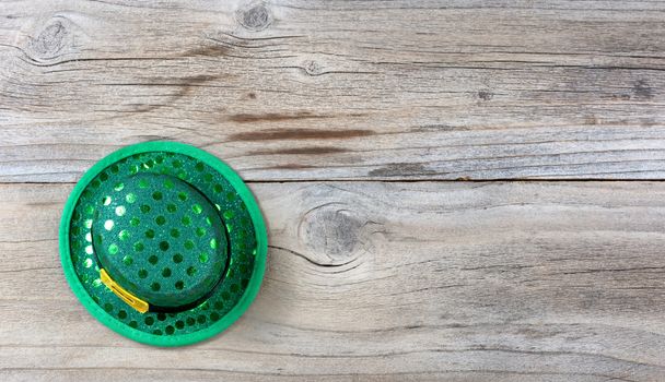 Lucky green hat for St Patrick on rustic wooden boards in overhead view 