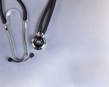 Overhead view of a medical stethoscope on stainless steel table