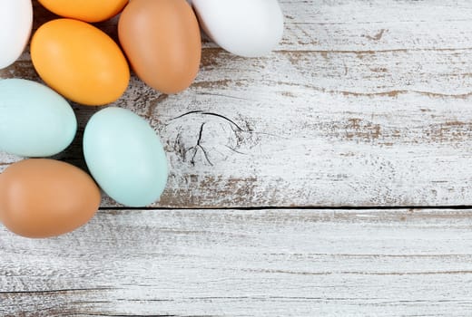 Close up of colorful real eggs on rustic white wood for Easter Background 