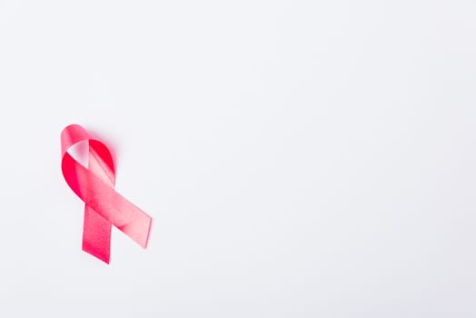 Breast cancer month concept, flat lay top view, pink ribbon on white background with copy space for your text