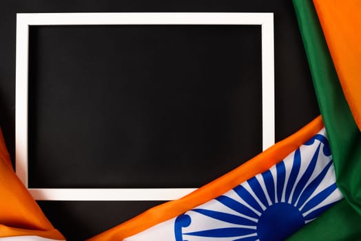 Indian republic day, flat lay top view, Indian flag and photo frame on black background with copy space for your text