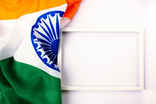 Indian republic day, flat lay top view, Indian tricolor flag and photo frame on white background with copy space for your text