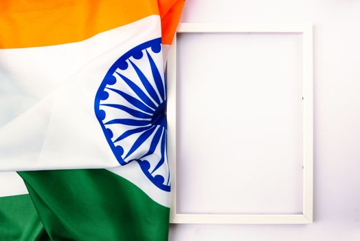 Indian republic day, flat lay top view, Indian tricolor flag and photo frame on white background with copy space for your text