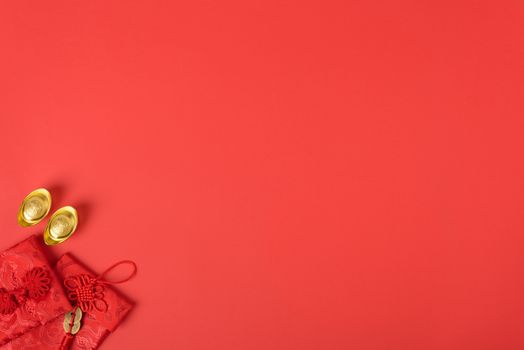 Chinese new year concept, flat lay top view, Happy Chinese new year with Red envelope and gold ingot (Character "FU" means fortune, blessing, wealth) on red background with copy space for your text