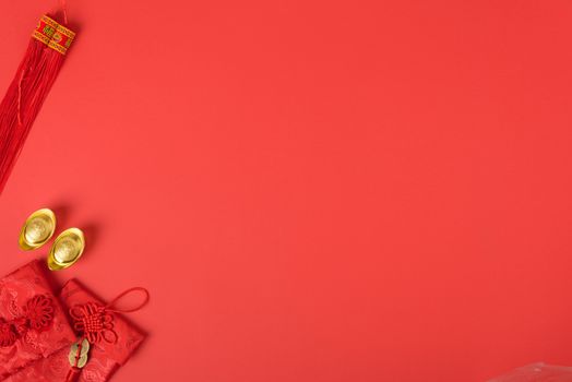 Chinese new year concept, flat lay top view, Happy Chinese new year with Red envelope and gold ingot (Character "FU" means fortune, blessing, wealth) on red background with copy space for your text