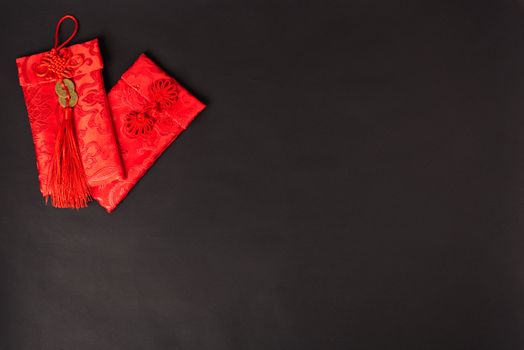 Chinese new year festival concept, flat lay top view, Happy Chinese new year with Red envelope (Character "FU" means fortune, blessing, wealth) on black background with copy space for your text