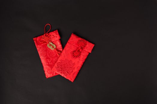 Chinese new year festival concept, flat lay top view, Happy Chinese new year with Red envelope (Character "FU" means fortune, blessing, wealth) on black background with copy space for your text