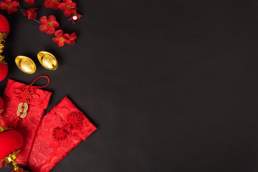 Chinese new year concept, flat lay top view, Happy Chinese new year with Red envelope and gold ingot (Character "FU" means fortune, blessing, wealth) on black background with copy space for your text