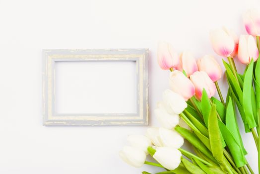 Happy Women's Day, Mother's Day and Valentine's Day concept. top view flat lay Tulip flower and photo frame on white background, copy space for your text