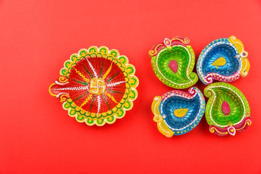 Happy Diwali Day, Flat lay top view Colorful Clay Diya lamps on red background and copy space for your text