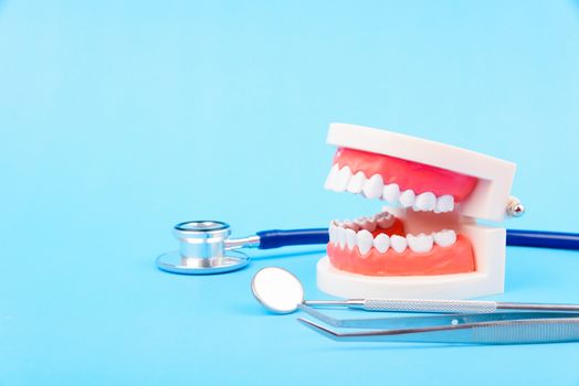 Dental Hygiene Health Concept, White tooth and Dentist tools for dental care on blue background