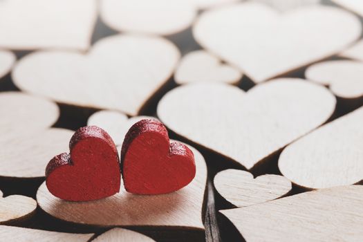 Many wooden colorless hearts background, two red special ones true love concept