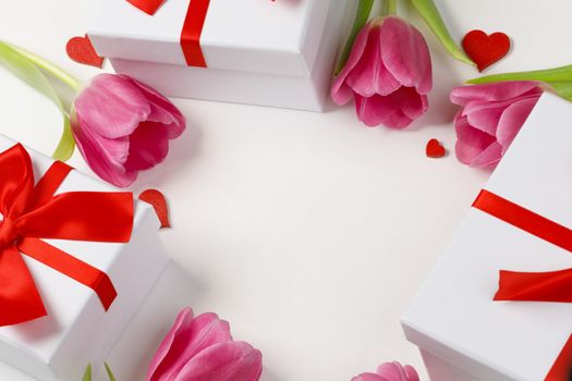 Pink tulip flowers gifts red hearts and gifts composition isolated on white background top view with copy space. Valentine's day, birthday, wedding, Mother's day concept. Copy space