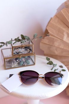 Beautiful fashion accessory for woman. Sunglasses on white and brown background. Copy space moke up accessories