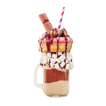 Chocolate and donuts extreme milkshake with marshmallow and other sweets in mason jar isolated on white. Crazy freakshake isolated on white with clipping path