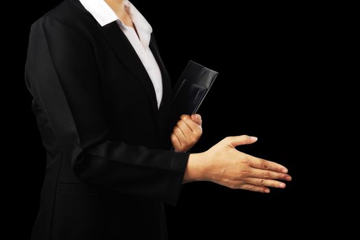 Businesswoman in black suit offering to shake the hand isolated on black background, clipping path.