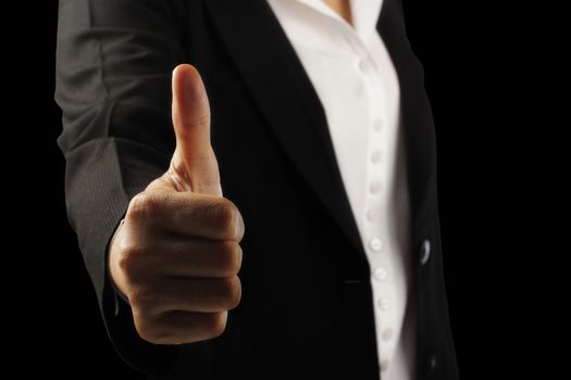 Businesswoman's hand showing thumb up sign isolated on black background, clipping path.