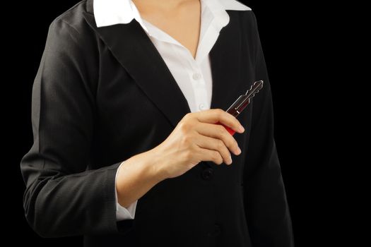 Businesswoman hand holding big key isolated on black background, clipping path.    