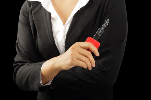 Businesswoman hand holding big key isolated on black background, clipping path.    