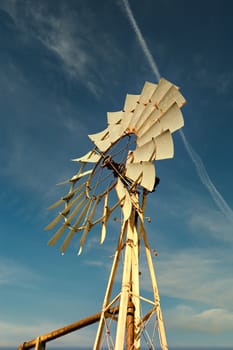 An old metal wind mill against a blue sky