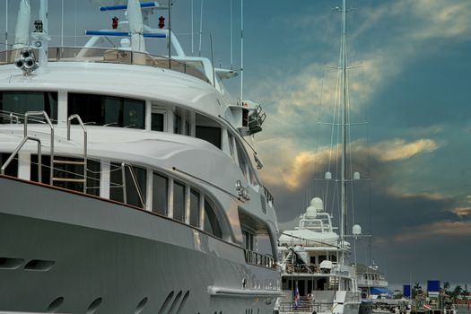 Two large white yachts tied up at a dock