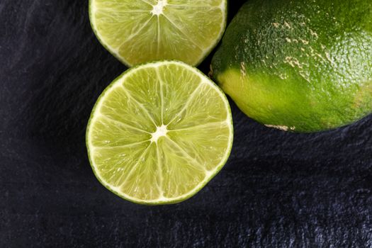Selective focus on sliced lime with whole and partial sliced limes in background 