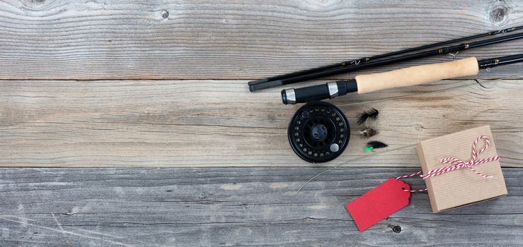 Fathers day gift box with fishing items on vintage wooden plank background