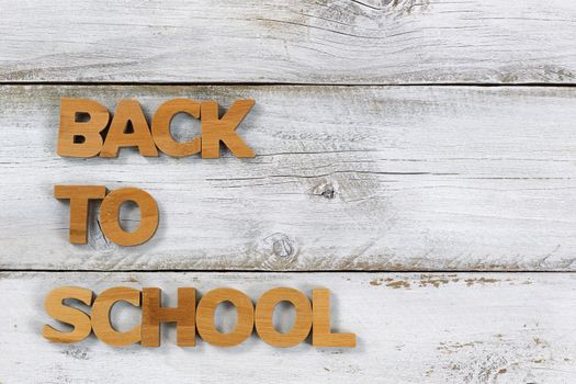 Wooden letters spelling back to school on rustic white boards.