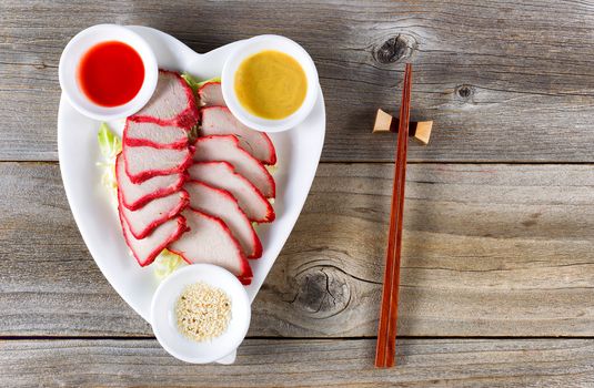 Top view Chinese sliced pork with special sauces on rustic wood. 