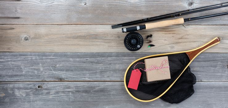 Fathers day gift box with fishing equipment on vintage wooden plank background