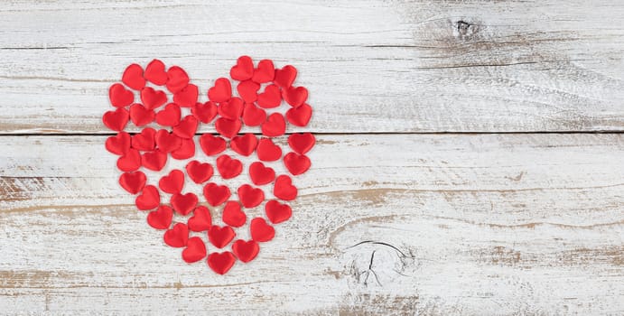 Filled red heart shapes on rustic white wood in flat lay view